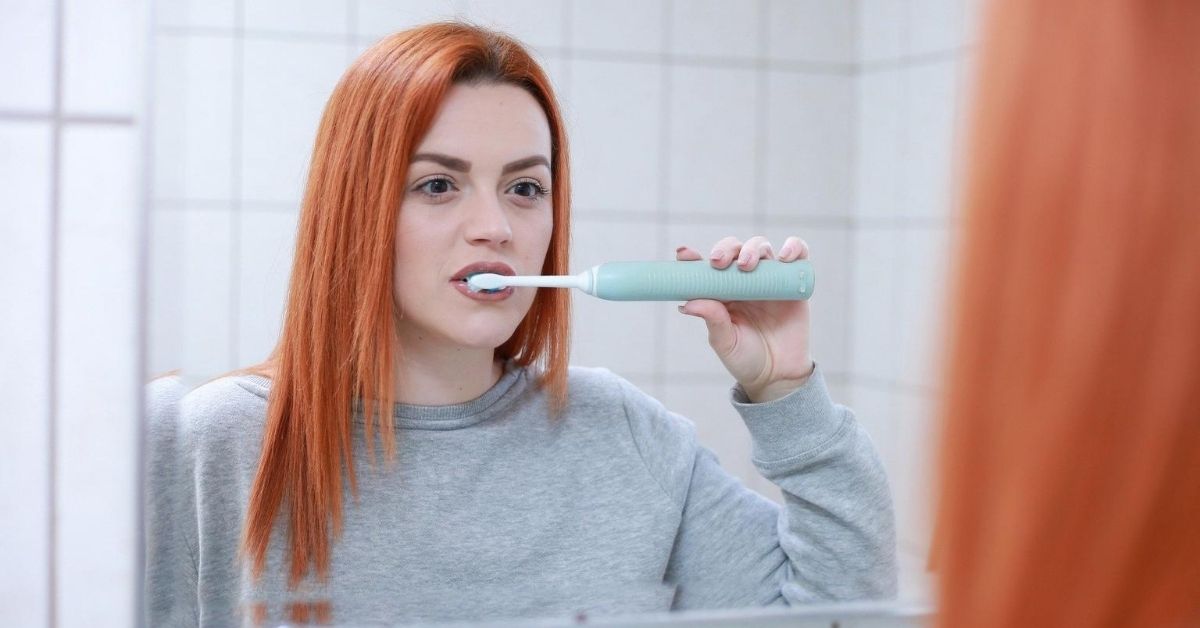 ryšavé dievča si umýva zuby